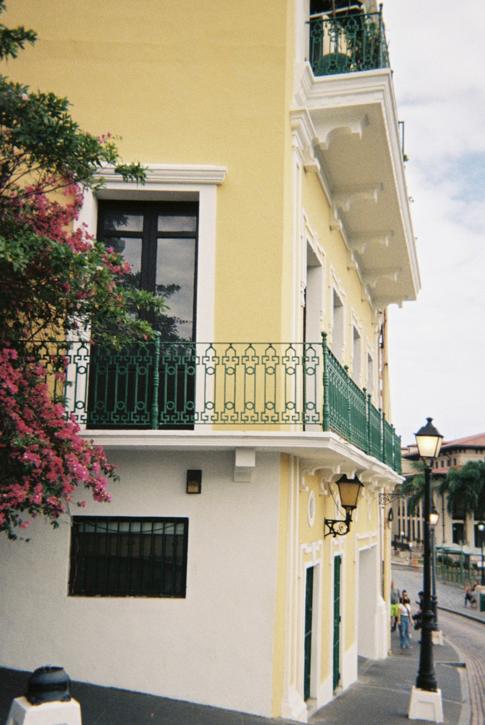 a yellow and white building with a balcony and balconies