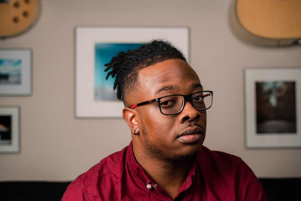 a man in a red shirt and black glasses