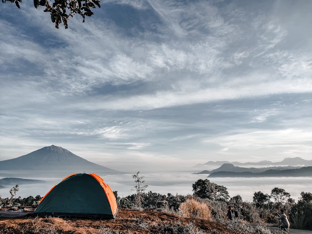 a tent pitched up on top of a hill