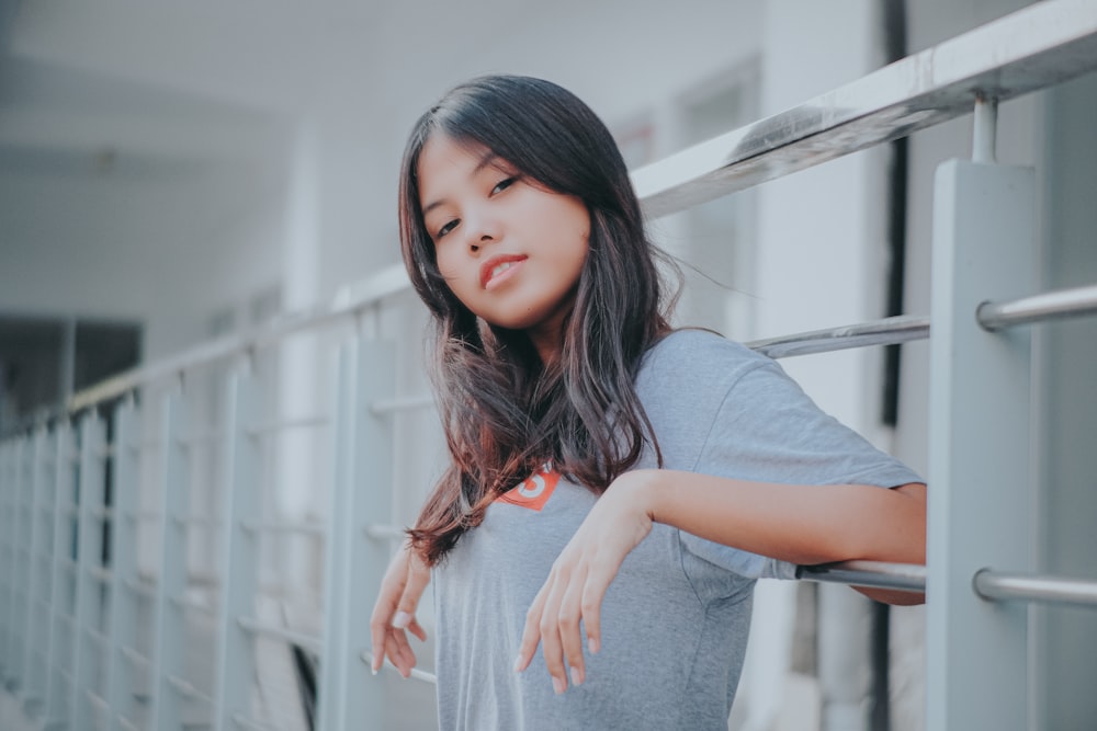 a young woman leaning against a metal railing