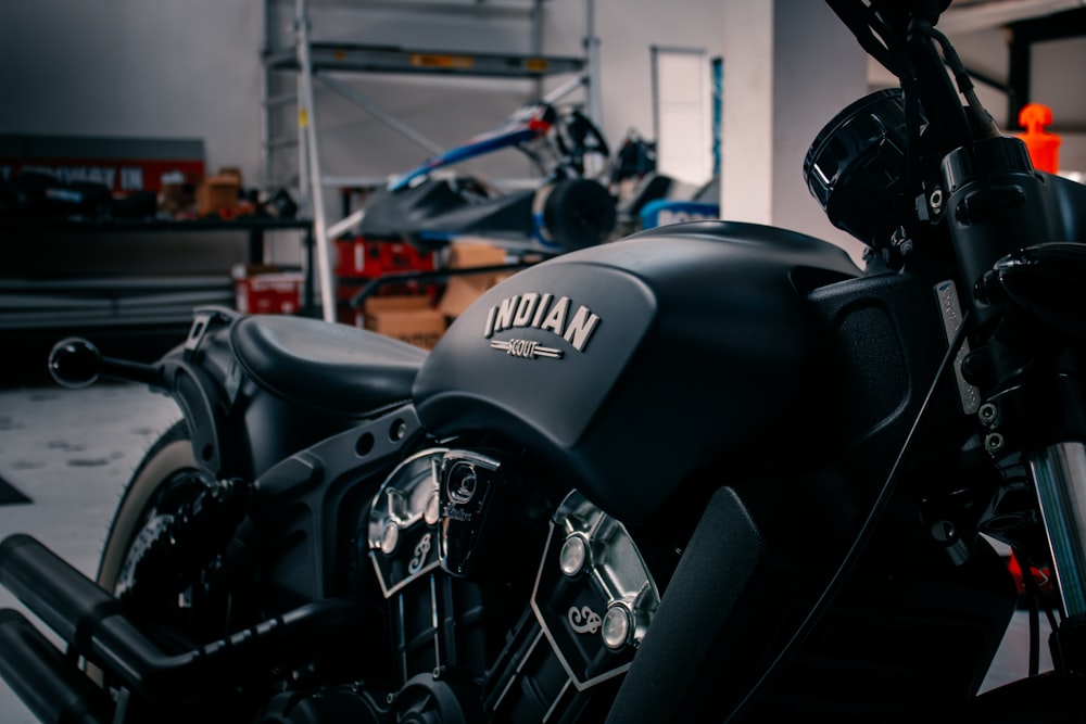 a black motorcycle parked in a garage next to other motorcycles