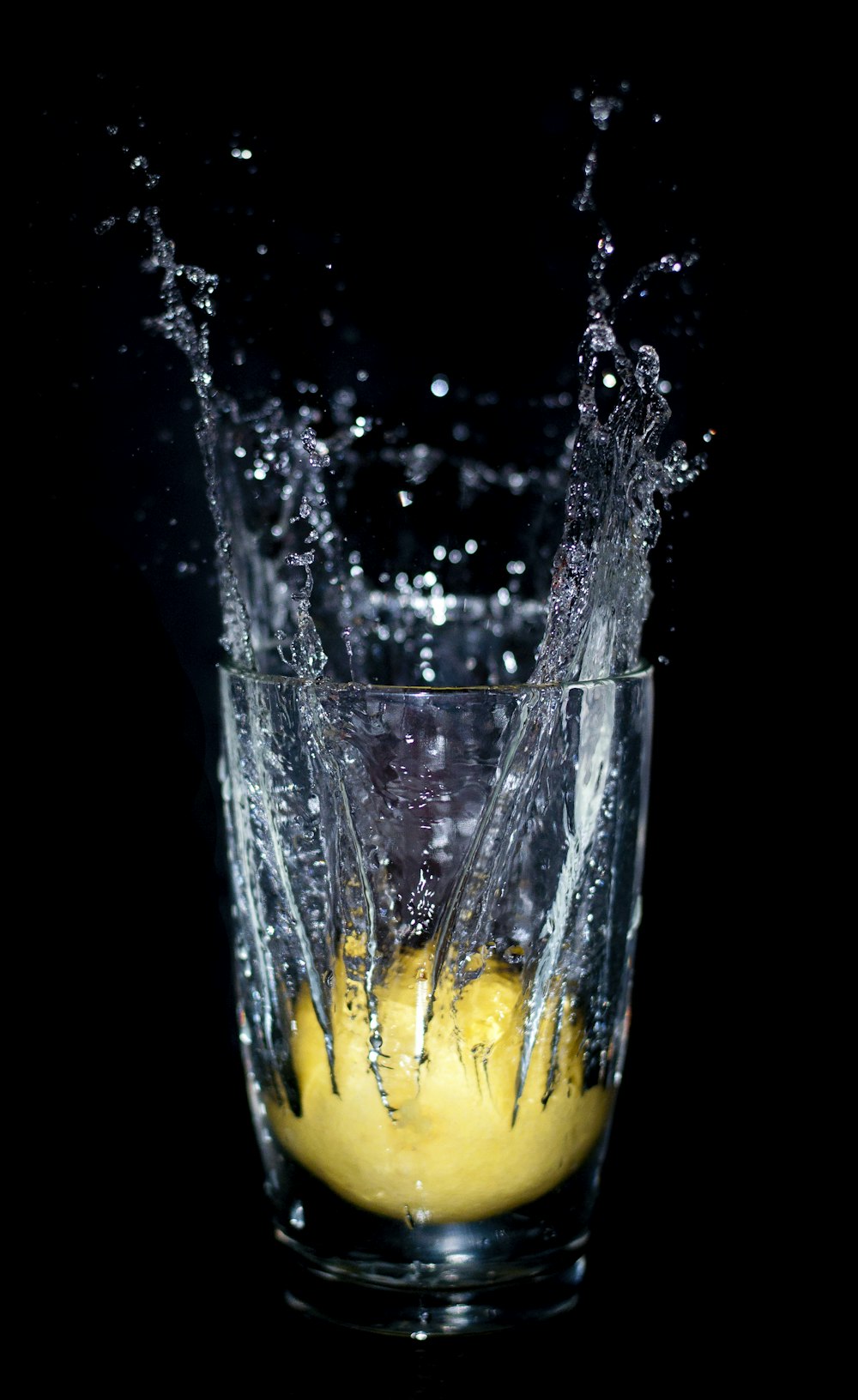 a glass filled with yellow liquid and water