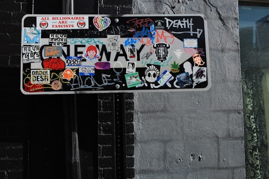 a street sign covered in lots of stickers
