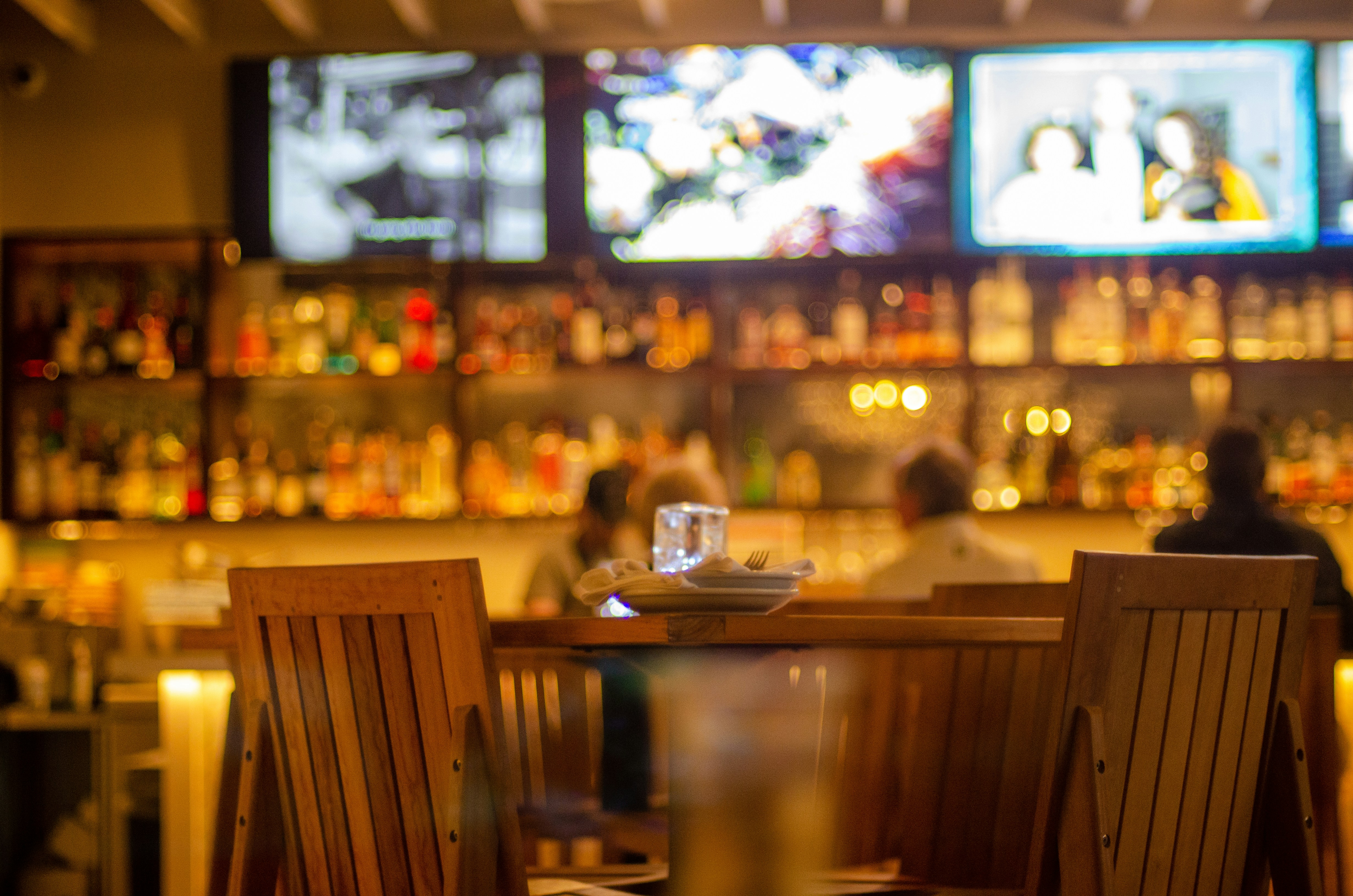 two people sitting at a table in front of a bar