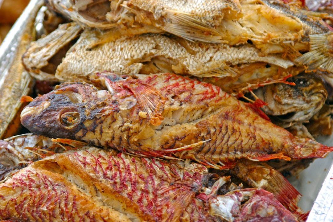 a pile of dead fish sitting on top of a table, Island-cooked pot fish ready to be served.
