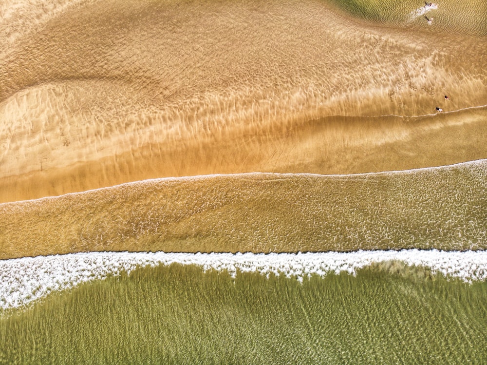 an aerial view of a sandy beach and ocean