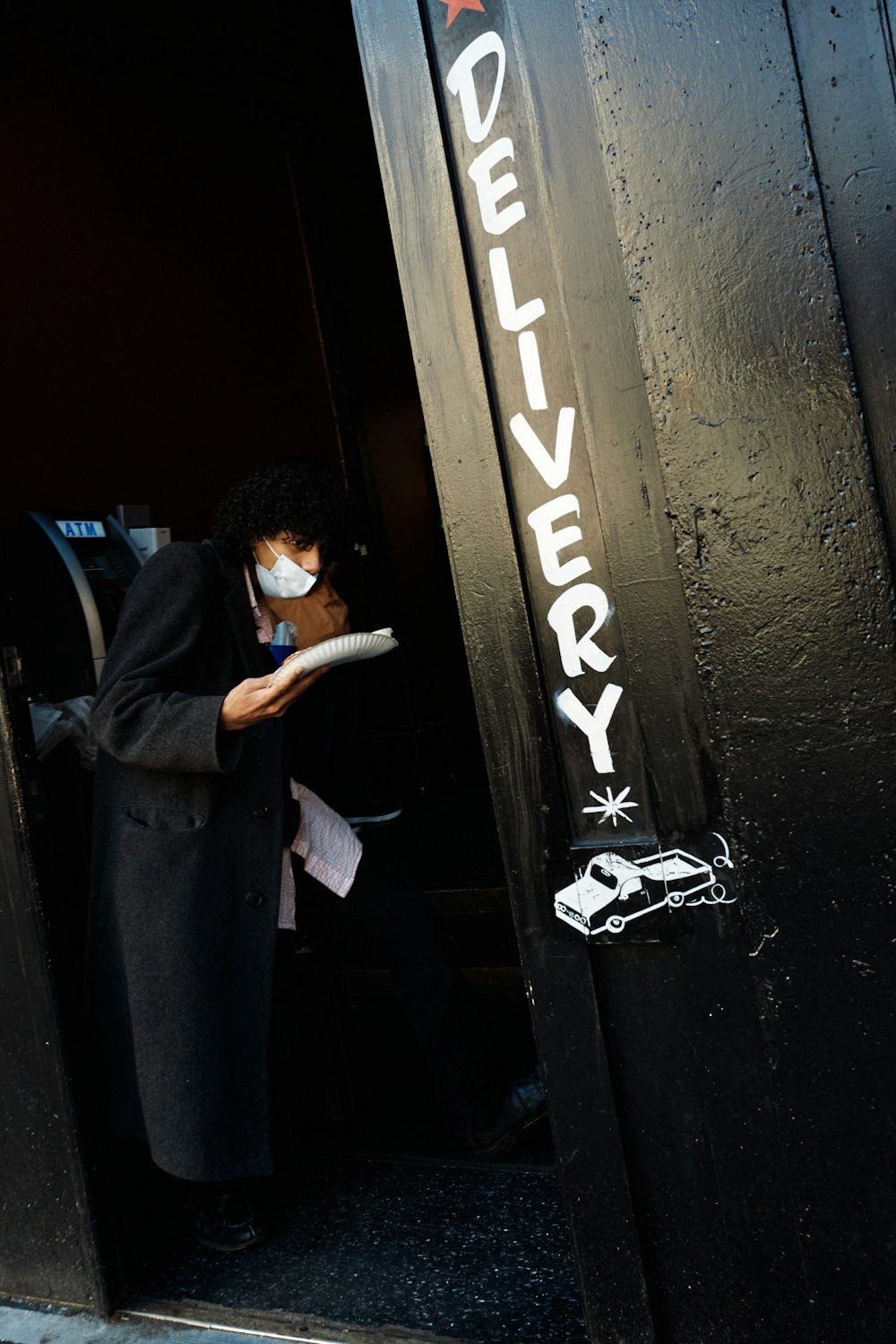 a man wearing a face mask standing in a doorway