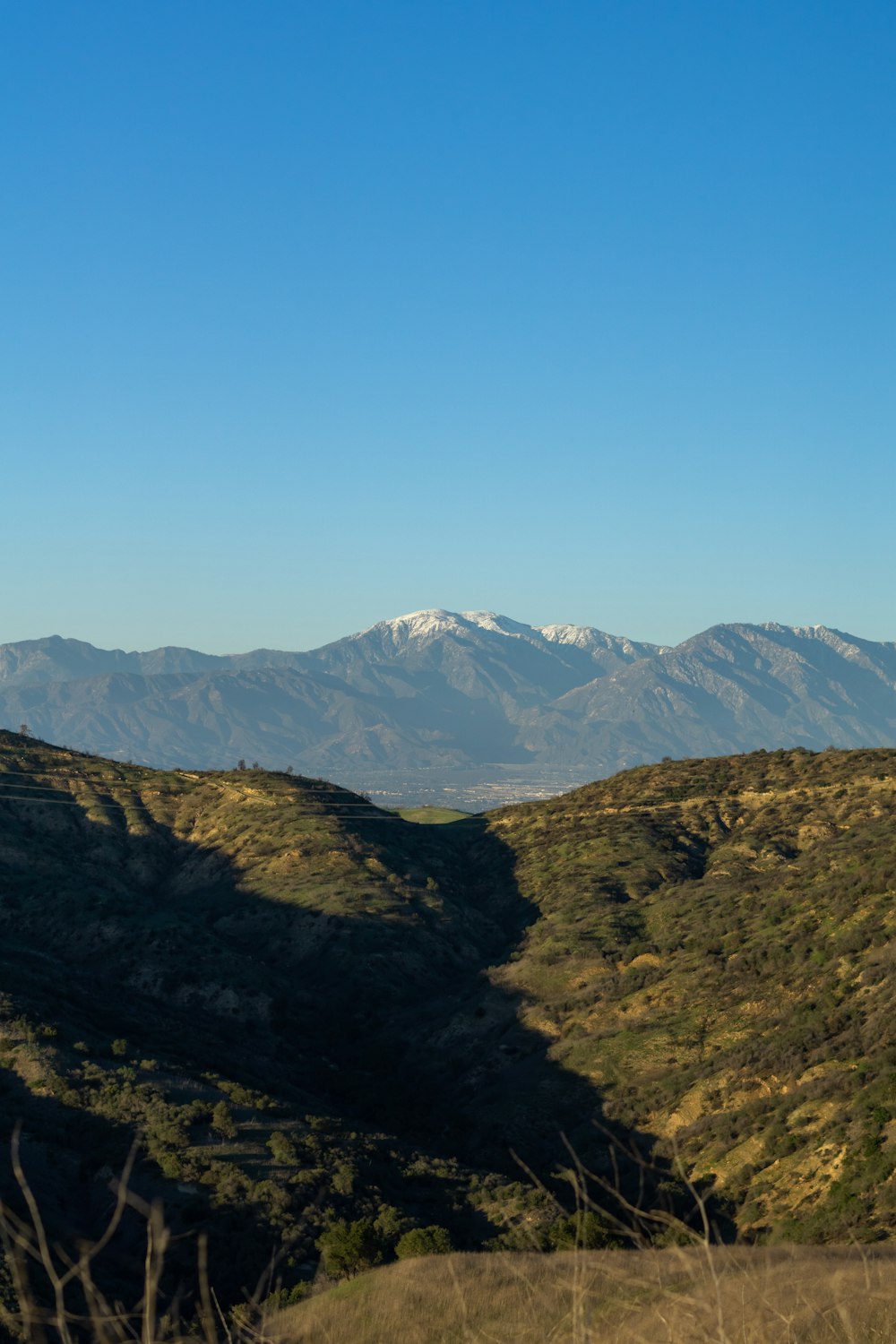 a view of a mountain range with snow capped mountains in the distance