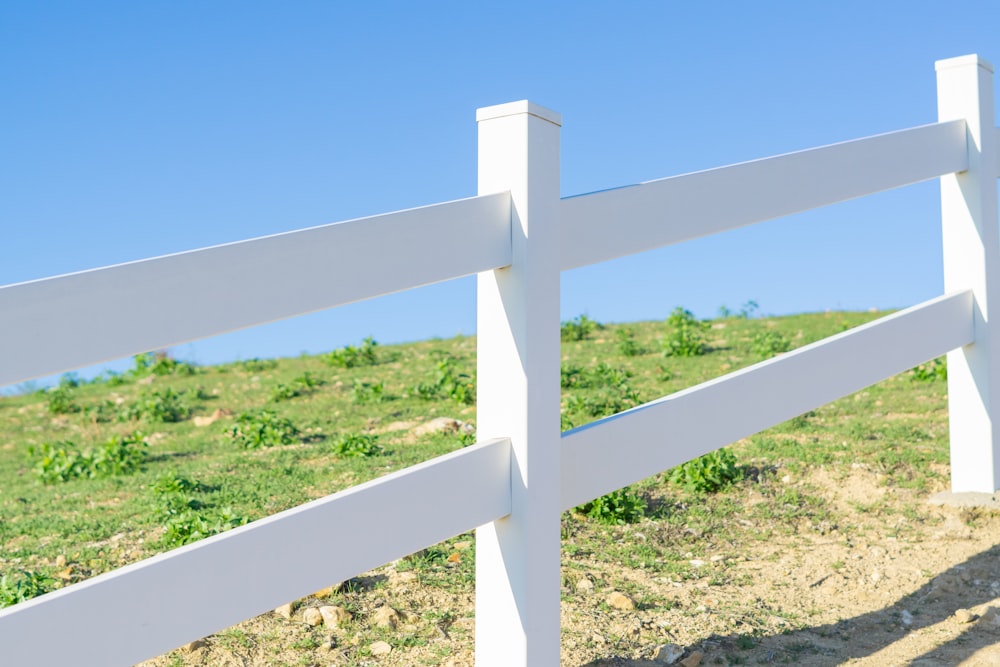 a close up of a white fence in a field