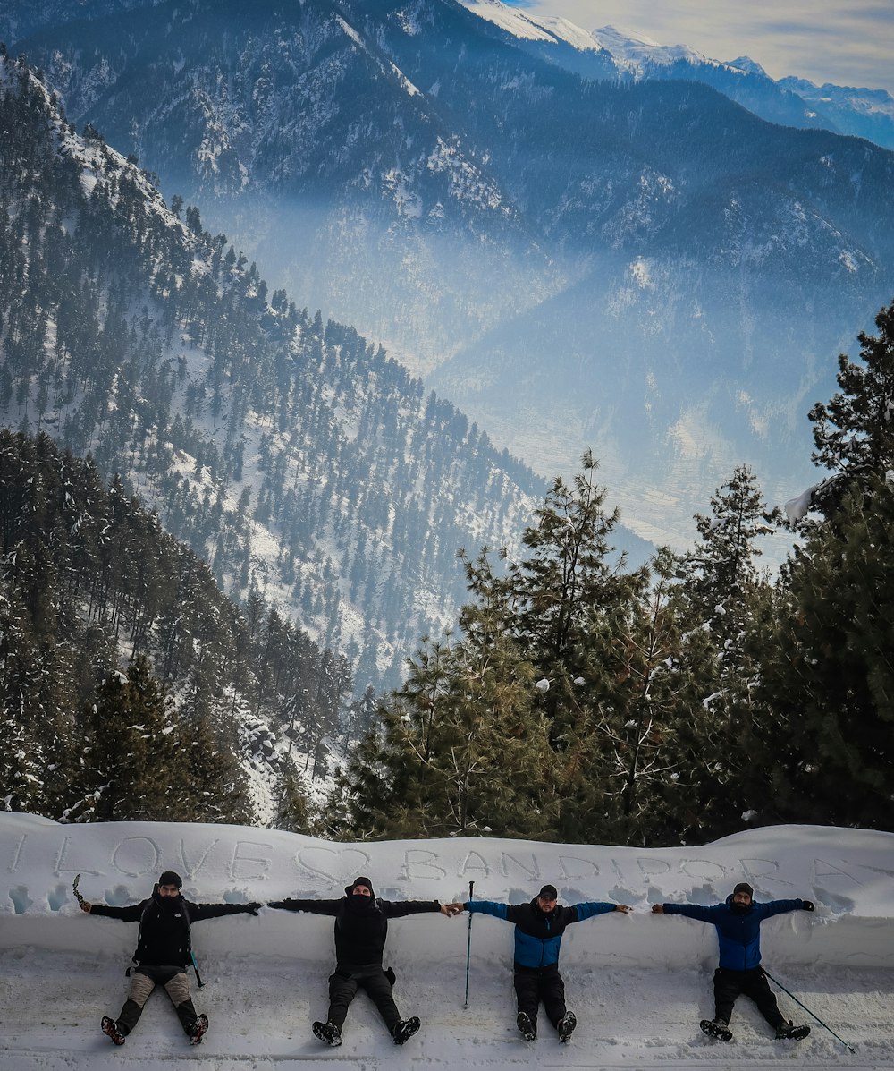 un gruppo di persone che cavalcano gli sci in cima a un pendio innevato