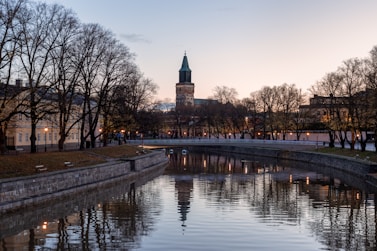 a river running through a city with a clock tower in the background