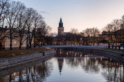 a river running through a city with a clock tower in the background