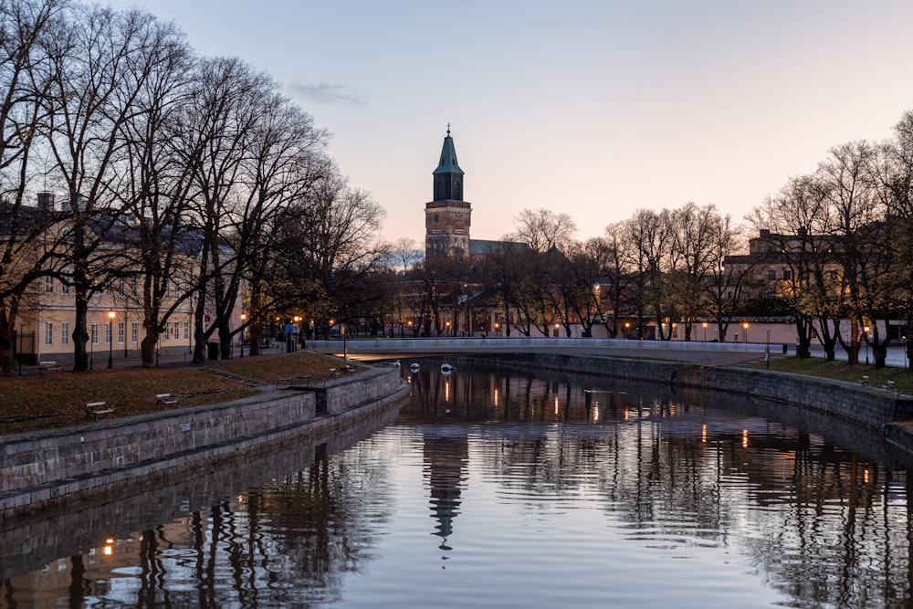 a river running through a city with a clock tower in the background