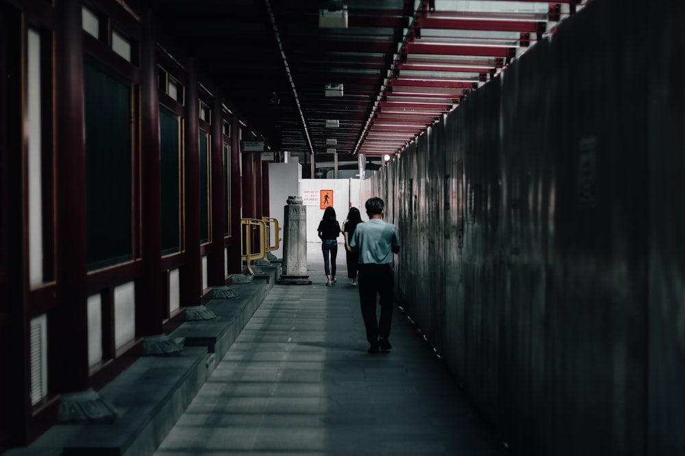 a couple of people walking down a hallway