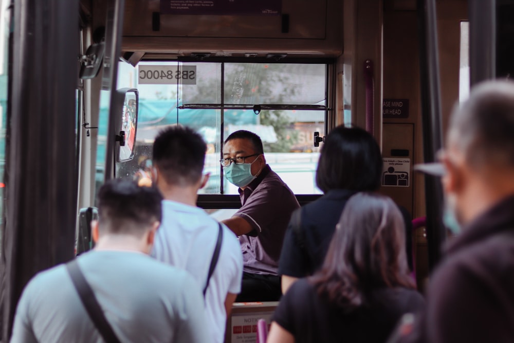 a group of people standing outside of a bus