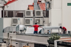 a couple of men standing on top of a roof