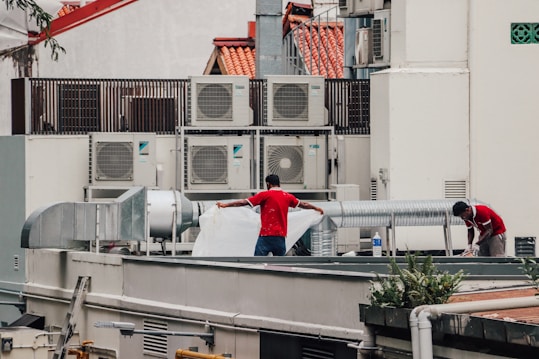 a couple of men standing on top of a roof