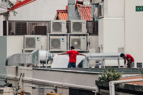 HVAC technicians servicing rooftop air conditioning units
