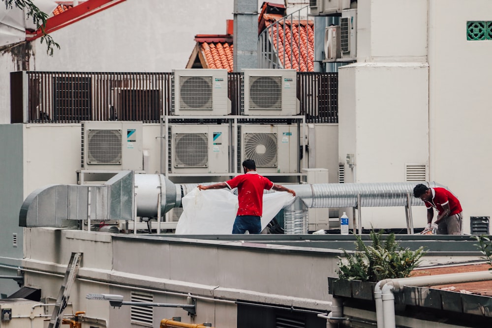 a couple of men standing on top of a roof