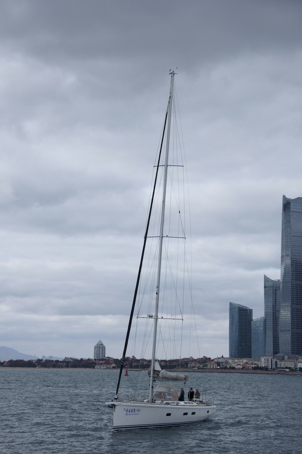 a sailboat in a body of water with a city in the background