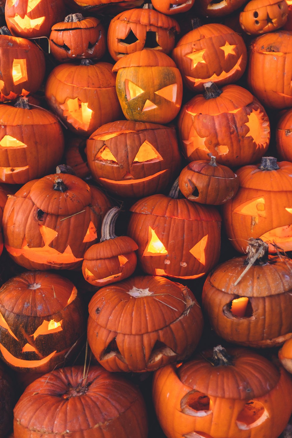 a pile of pumpkins with faces carved into them