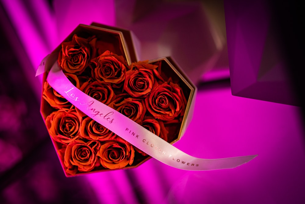 uma caixa em forma de coração cheia de rosas vermelhas