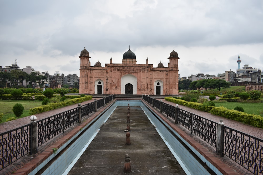 a large building with a long pool in front of it