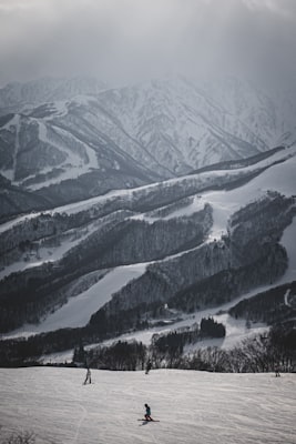 Snow-covered ski runs winding through wooded ridgelines in the Nagano mountains