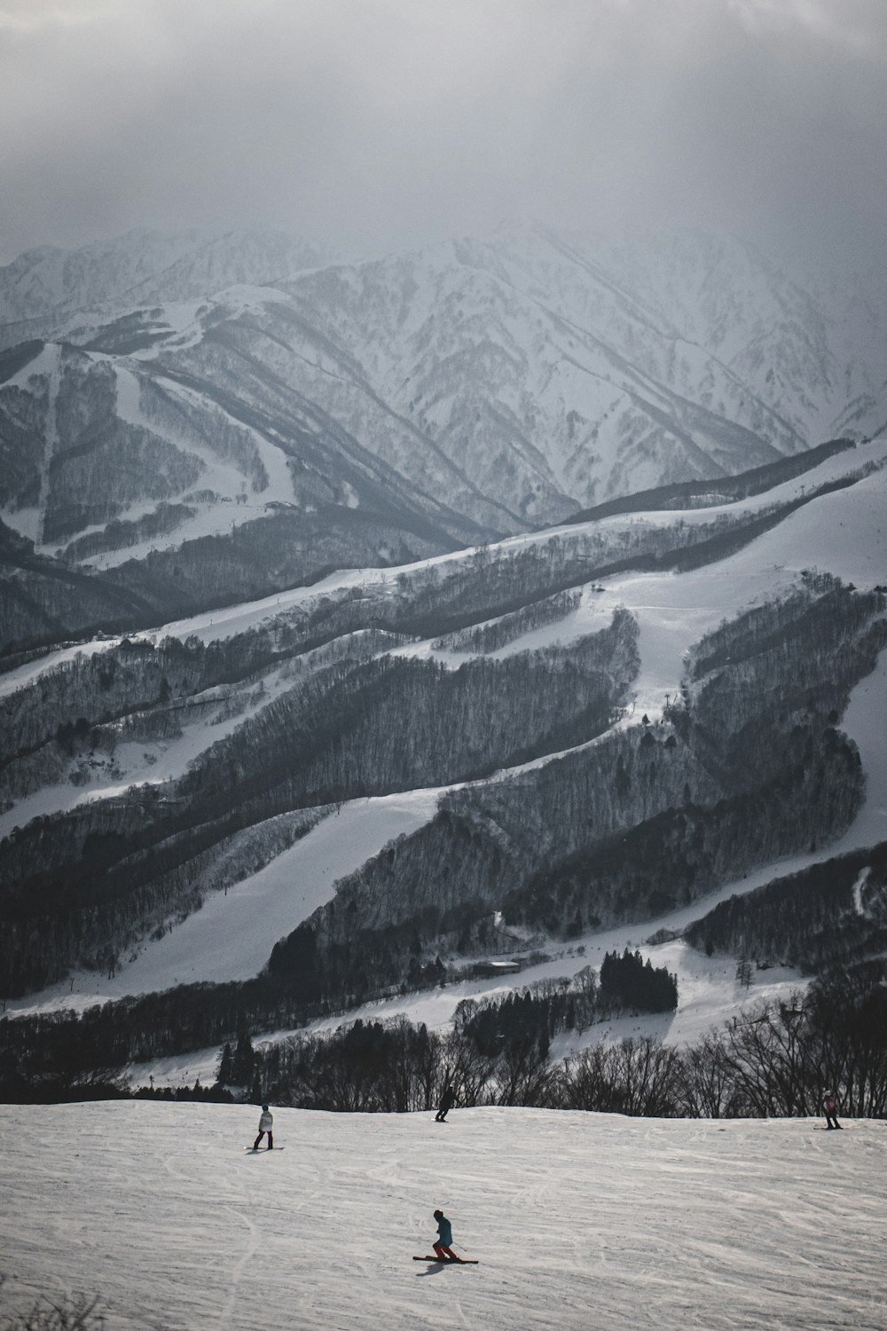 a couple of people riding skis on top of a snow covered slope