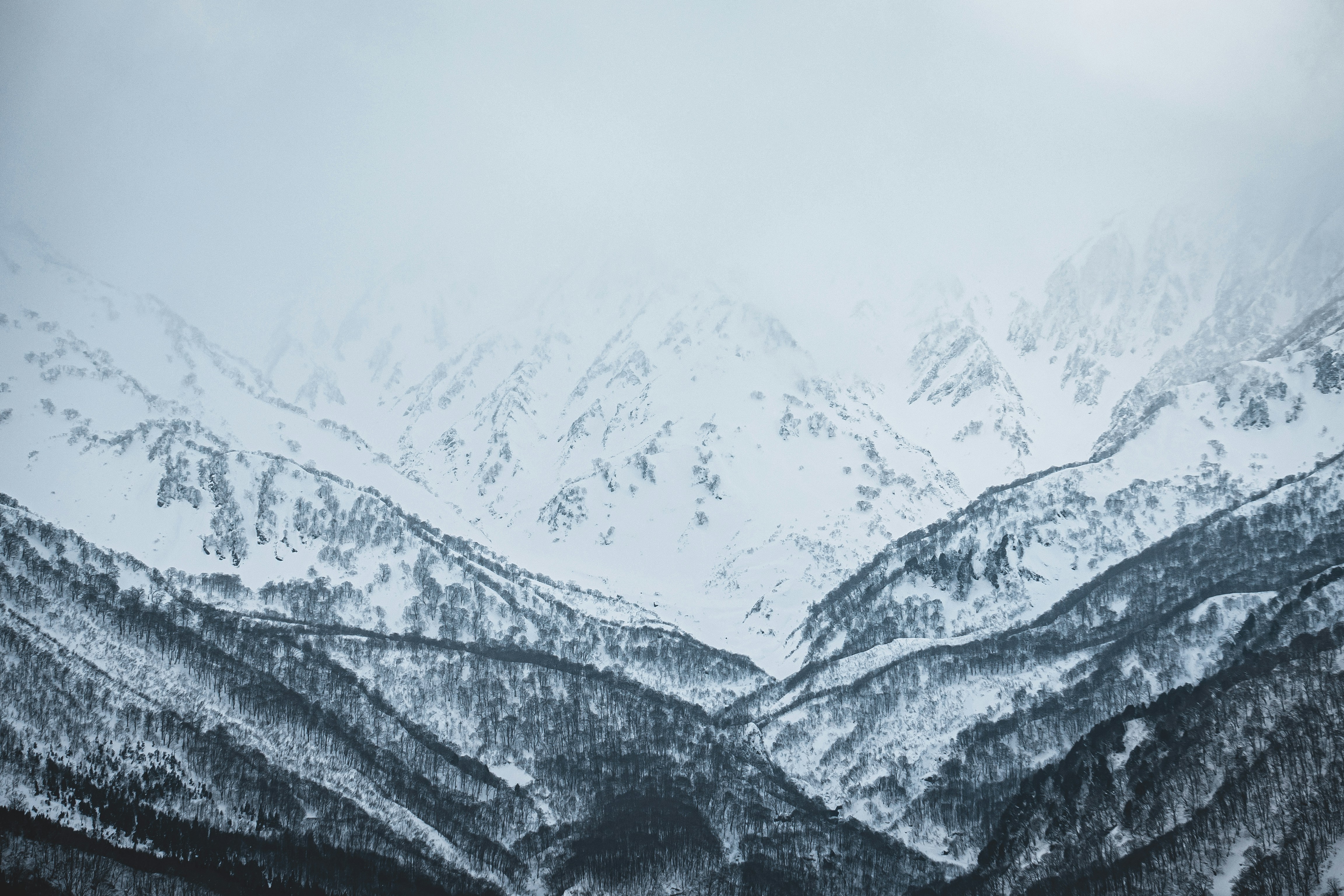 a mountain range covered in snow in the winter