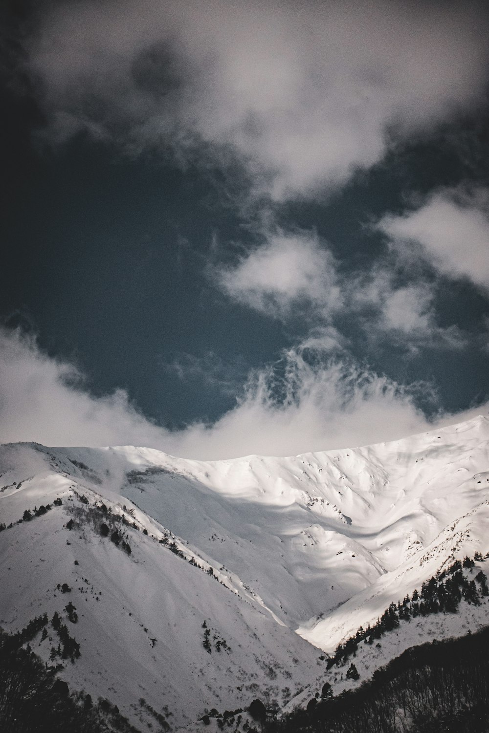 Una montagna coperta di neve sotto un cielo nuvoloso