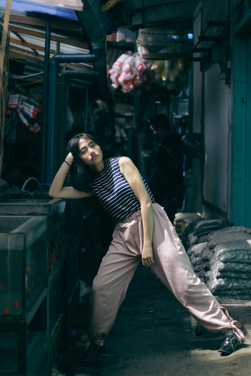 a woman leaning against a wall in a market