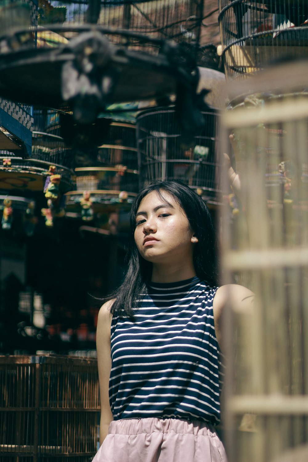 a woman standing in front of a bird cage