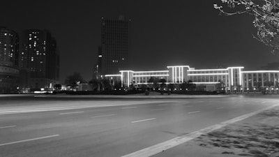 Nighttime cityscape highlighting illuminated buildings and quiet streets.