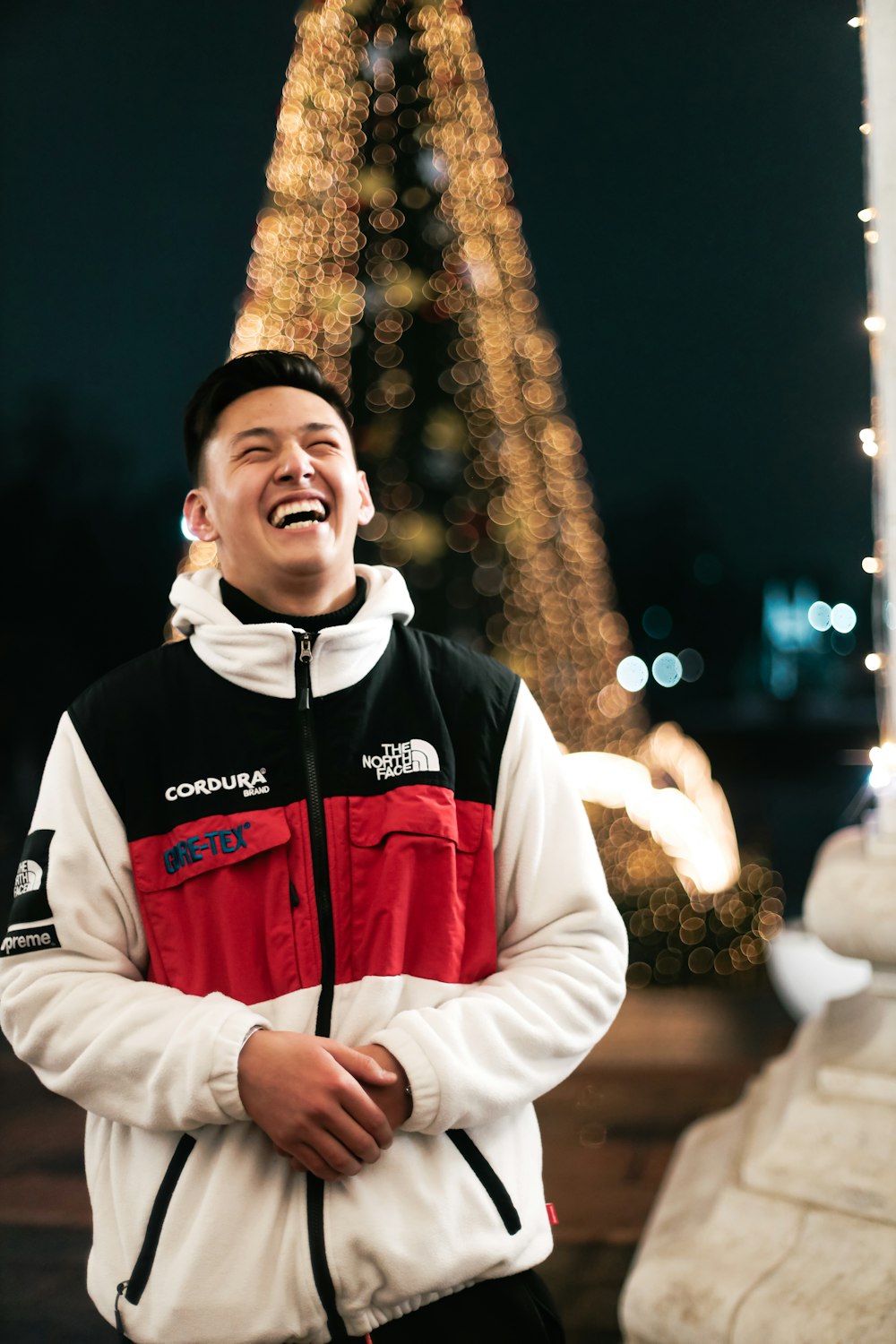 a man standing in front of a christmas tree