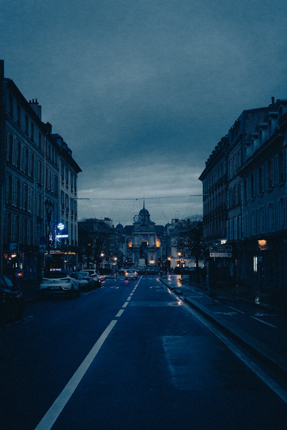 a city street at night with cars and buildings