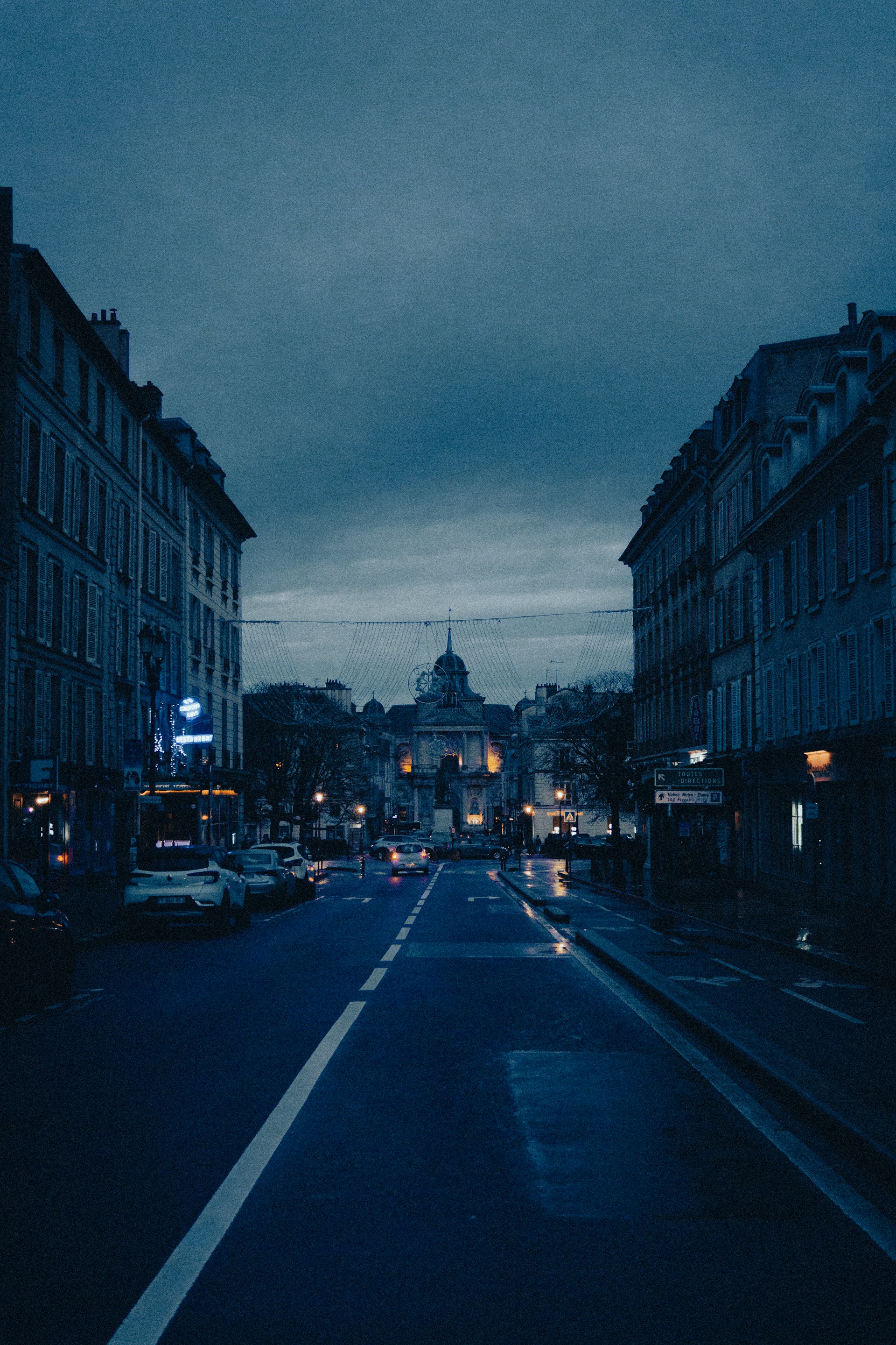 A moody, rain-soaked city street at dusk, capturing the quiet tension of a cinematic moment.