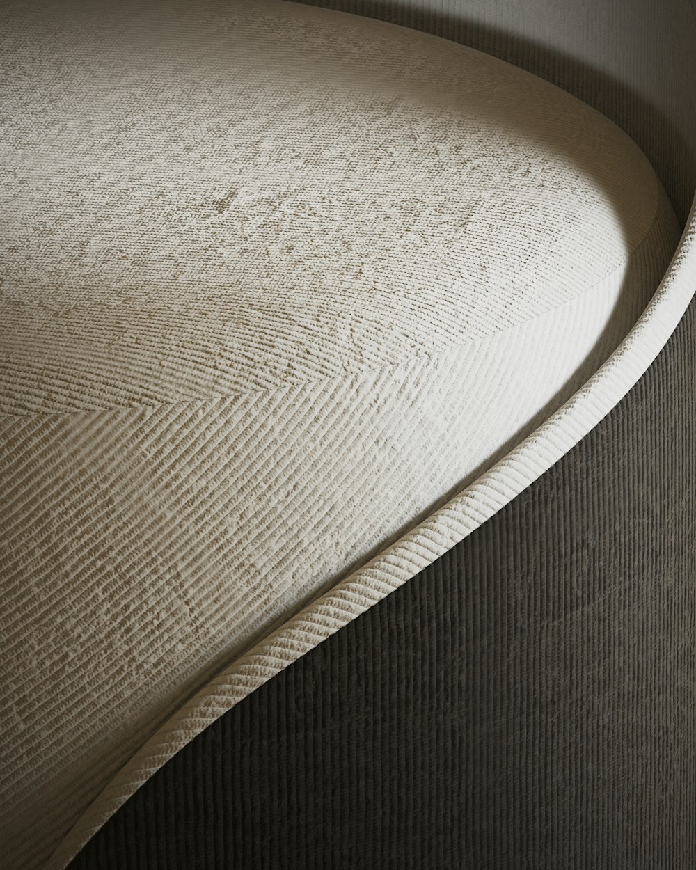 a close up of a bed with a curved headboard