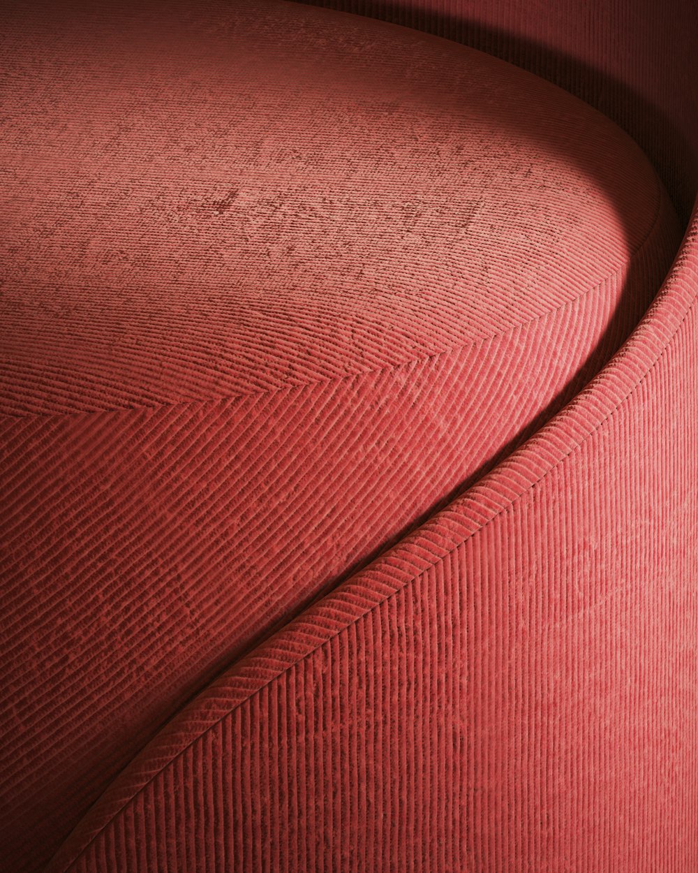 a close up of a red chair with a curved seat