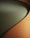 A close-up view of a piece of furniture with a textured, ribbed fabric surface in a warm, earthy brown color, forming a smooth, gently curving shape. The seat cushion is upholstered in a solid, muted green fabric, providing a contrasting texture and color.