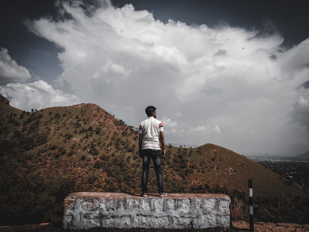 a man standing on top of a stone wall