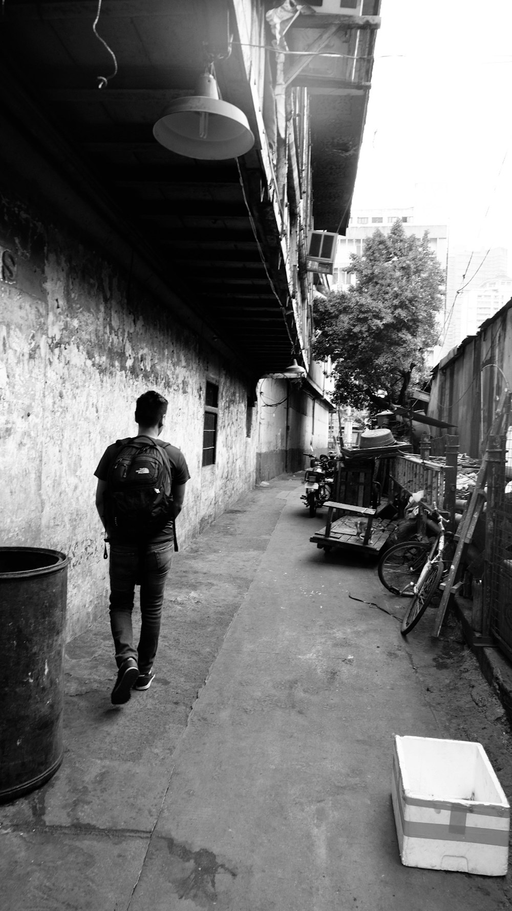 a black and white photo of a person walking down a street