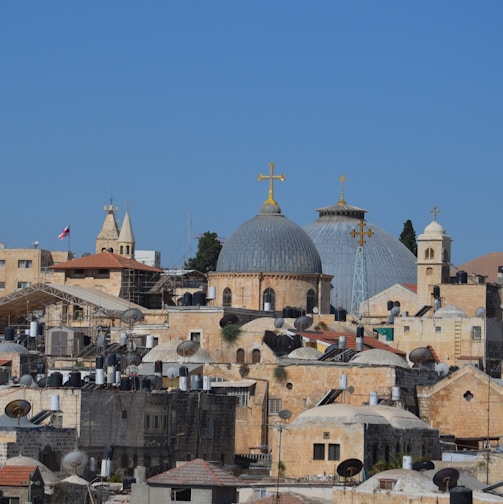 a city with a lot of buildings and a cross on top of it