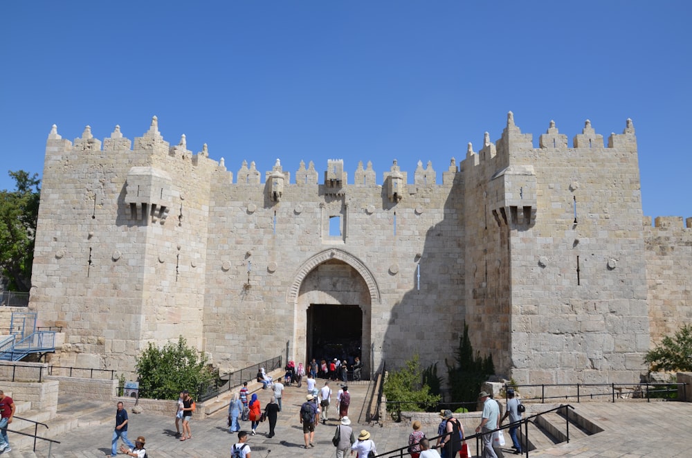 a group of people standing in front of a castle