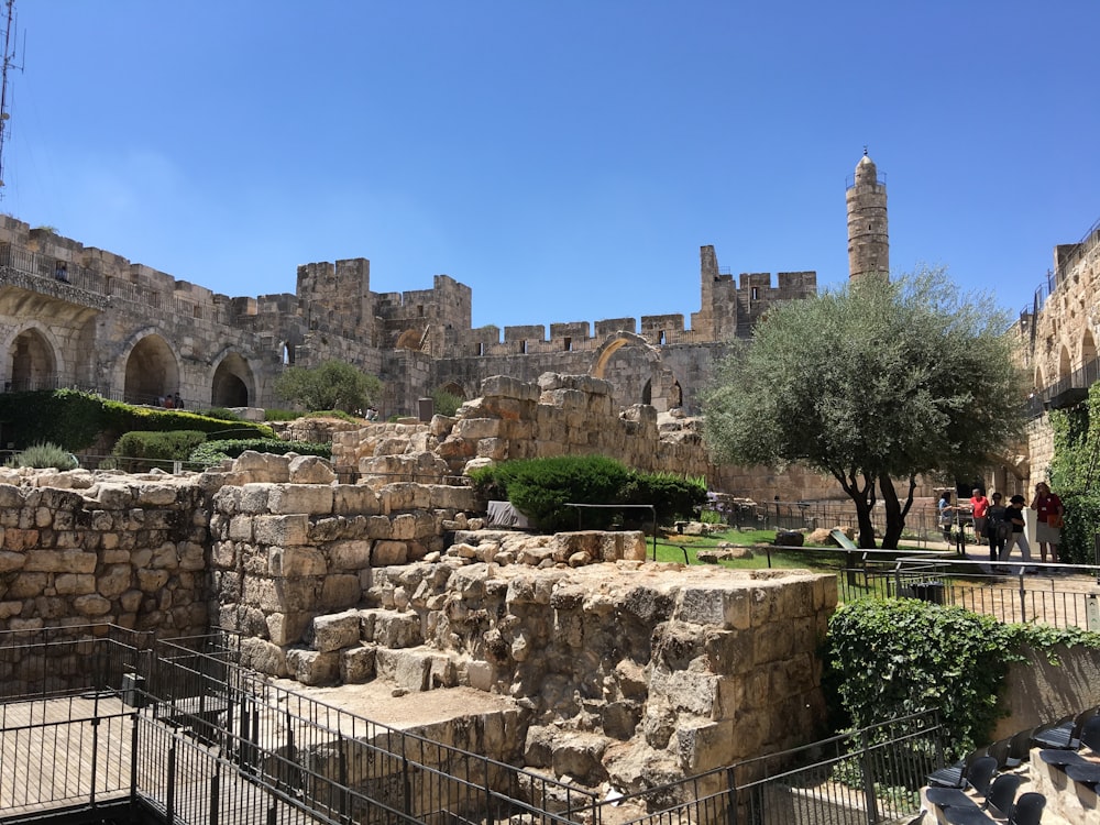 a group of people walking around a stone building