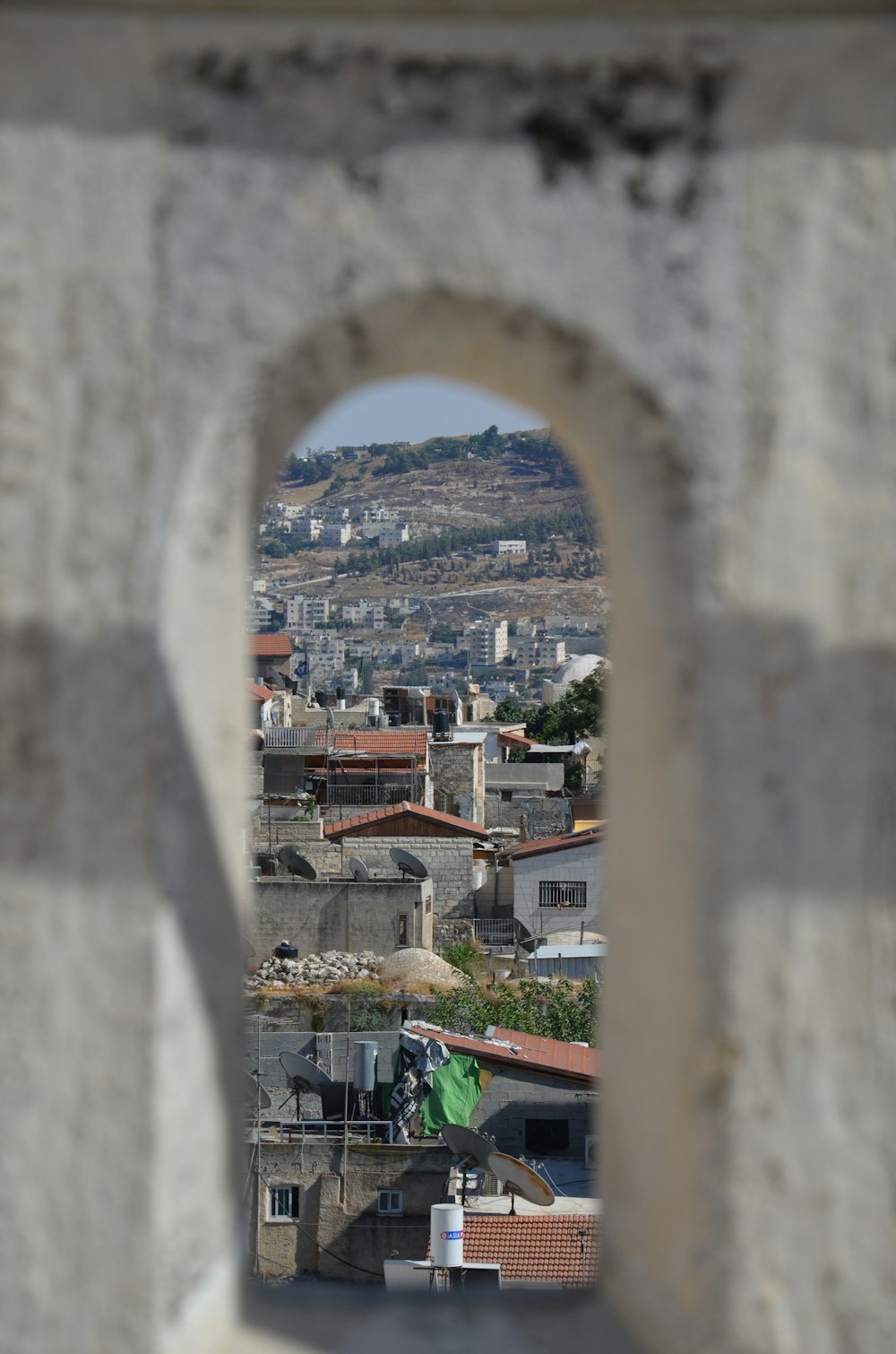 a view of a city through a hole in a stone wall