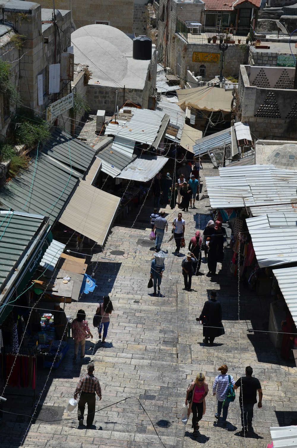 a group of people walking down a street next to buildings