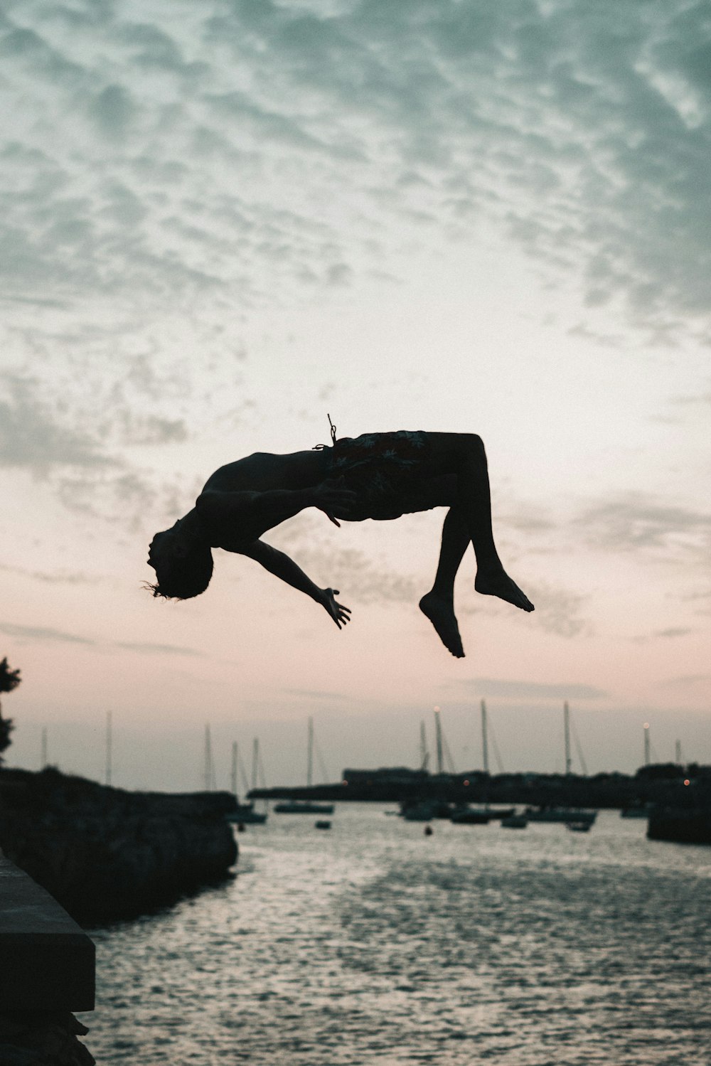 a person jumping into the air from a dock