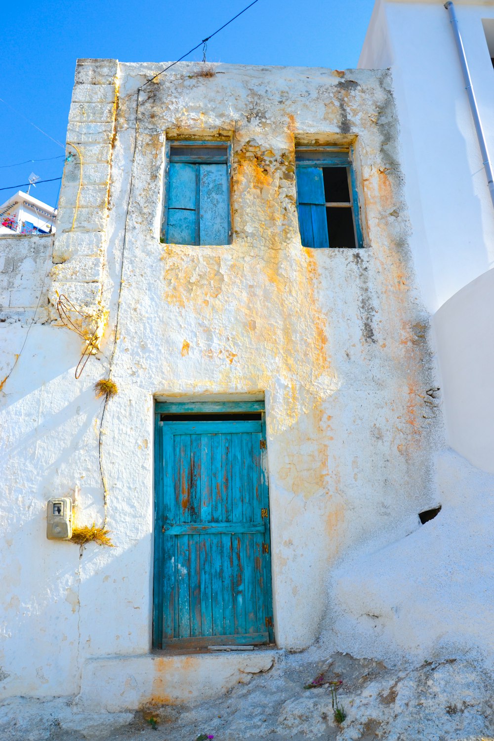 a white building with a blue door and window