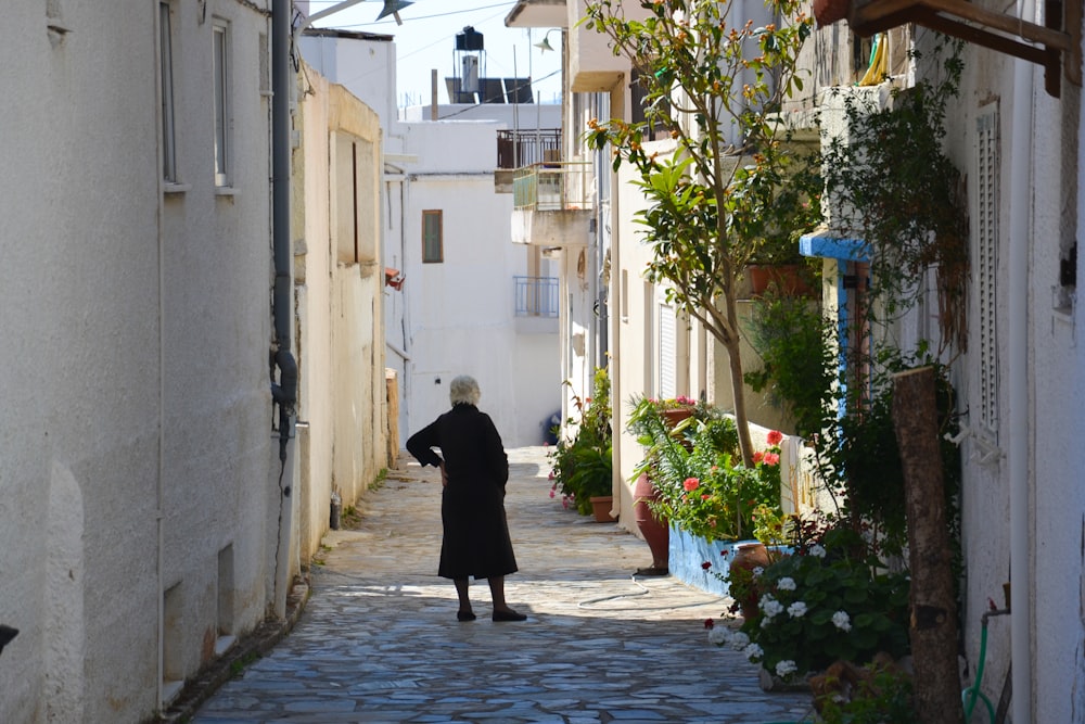 a woman walking down a narrow alley way